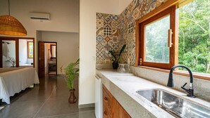 Una cocina moderna con un amplio ventanal, un lavamanos y una planta en maceta.