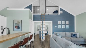 Un espacio habitable en varios niveles con una zona de cocina, una escalera y un área de estar.