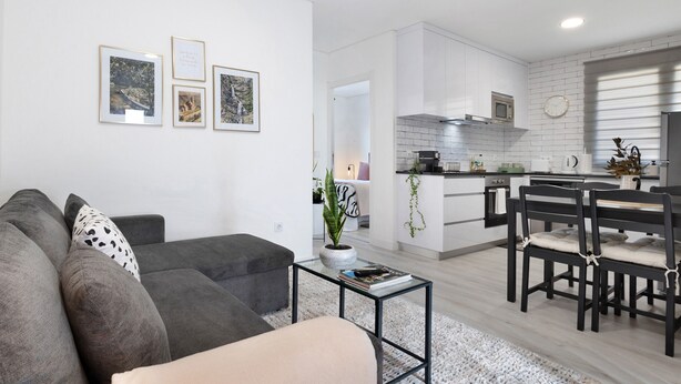 A modern living room with a sofa, coffee table, and framed pictures on the wall.