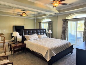 A bedroom with a large bed, two bedside tables, a ceiling fan, and a view of the outdoors. - Gated Luxury Condo Overlooking The Intercoastal Waterway  & Centrally Located (Myrtle Beach)