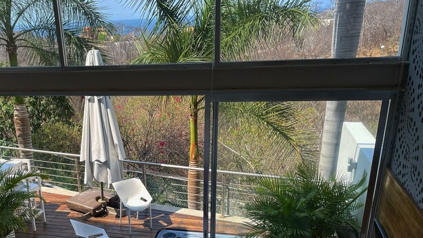 A balcony with a hot tub, chairs, and potted plants. - Huatulco Loft 411 PG 5 minutes from El Arrocito Beach (El Arrocito, Huatulco)