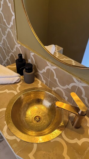 A bathroom with a gold sink, a mirror, and a towel. - Riad Nouha • Piscine privative • Toit-terrasse • Petit-déjeuner (Marrakech)
