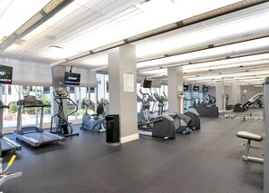 Ein Fitnessstudio mit Laufbändern, Crosstrainern und Gewichtsmaschinen.