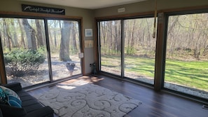 A room with large sliding glass doors, a dark-colored sofa, a patterned rug, and a small table with a decorative item.