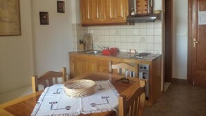Una cocina con armarios de madera, un salpicadero de azulejos, un lavabo y una estufa.