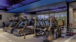 Uma academia com esteiras, elípticos e equipamentos de musculação.