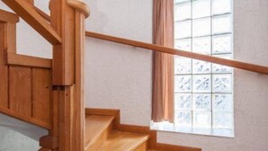 A wooden staircase with a handrail, a window with frosted glass, and a light-colored wall. - Guest House Stay & Smile Dolac Primošten - Studio with Sea View and Balcony (Primosten)