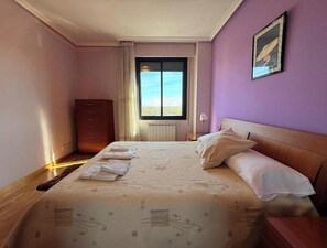 Tabla de planchar con plancha y ropa de cama