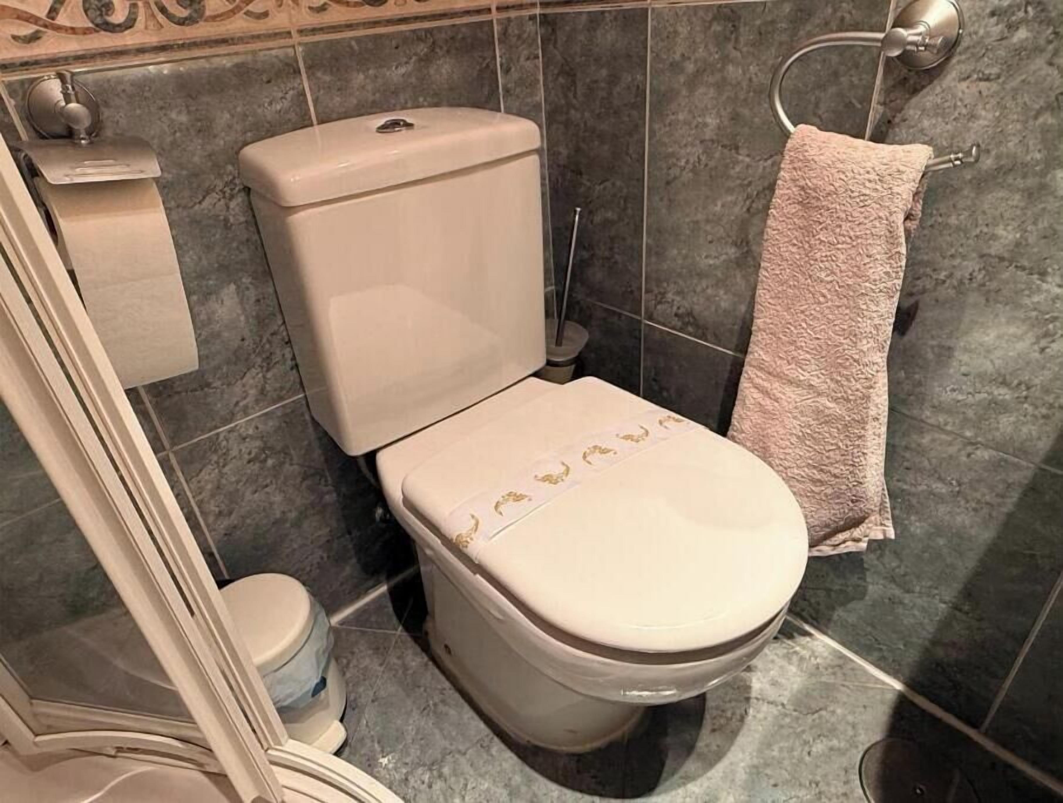 A bathroom with a toilet, a bidet, and a towel rack.