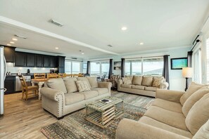 A spacious living area with a sofa, a coffee table, and a dining table.