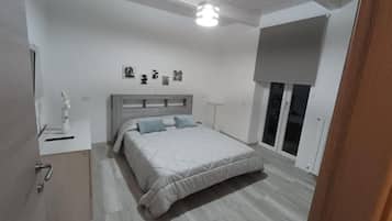 Ein Schlafzimmer mit Bett, Nachttisch und Fenster mit Blick.