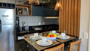 A modern kitchen with a central island, stainless steel appliances, and wooden accents. - Altamare 203 - Luxury and comfort right on the sand at Caribessa beach. (João Pessoa)