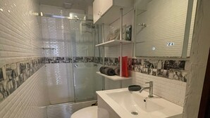 Ein modernes Badezimmer mit Toilette, Waschbecken und Dusche.