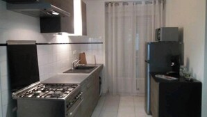 A modern kitchen with a gas stove, a built-in oven, a microwave, and a refrigerator.