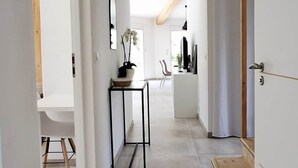 Un intérieur moderne avec un couloir menant à une salle à manger, une cuisine et un espace de vie.
