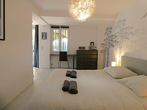 Ein Schlafzimmer mit einem großen Bett, einem Schreibtisch, einem Stuhl und einer Kommode.