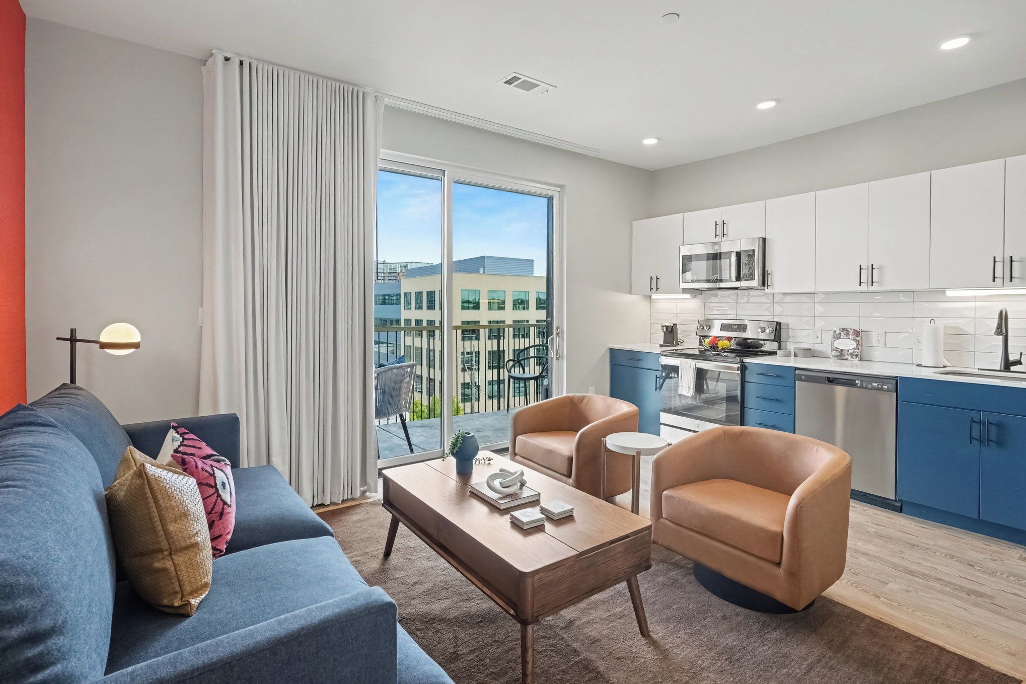 A modern apartment with a living room, kitchen, and balcony.