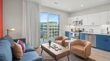 A modern apartment with a living room, kitchen, and balcony.