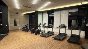 Un gimnasio con cintas de correr, elípticas y bicicletas estáticas.