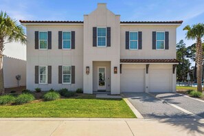 A two-story house with a garage, a front door, and a well-maintained lawn. - Community pool, Hot Tub + Tops'l Beach Access (Miramar Beach)