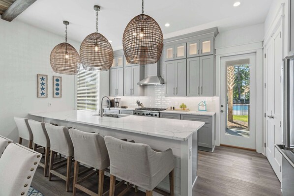 A modern kitchen with a large island, pendant lights, and a view to the outside. - Community pool, Hot Tub + Tops'l Beach Access (Miramar Beach)