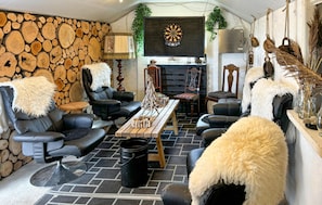 A cozy living room with leather sofas, a wooden coffee table, and a stone wall.