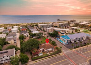 An aerial view of a coastal town with a marina, beachfront, and a hotel with a pool. - Fire & Oaks Estate (Tybee Island)