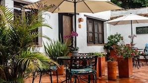 A patio area with outdoor seating, potted plants, and hanging planters. - Pancha Mama Hotel Boutique (Villa de Leyva)
