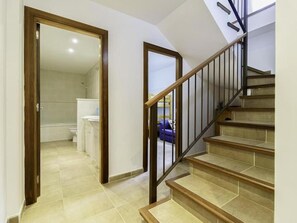 Eine Treppe mit Holzbodenstufen und Metallgeländern, die zu einer oberen Etage führt.