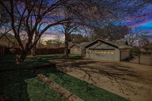 A residential property with a garage, a driveway, and a large tree. - Candleridge Casa - Newly Remodeled 4-bd Hidden Gem (Fort Worth)