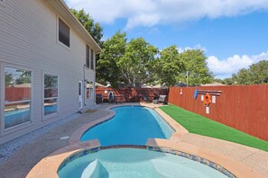 A backyard with a swimming pool, a wooden fence, and a house. - Modern Comforts & Classic Charm w Pool, 5BD (Fort Worth)