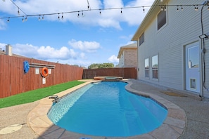 A backyard with a swimming pool, a wooden fence, and a house. - Modern Comforts & Classic Charm w Pool, 5BD (Fort Worth)