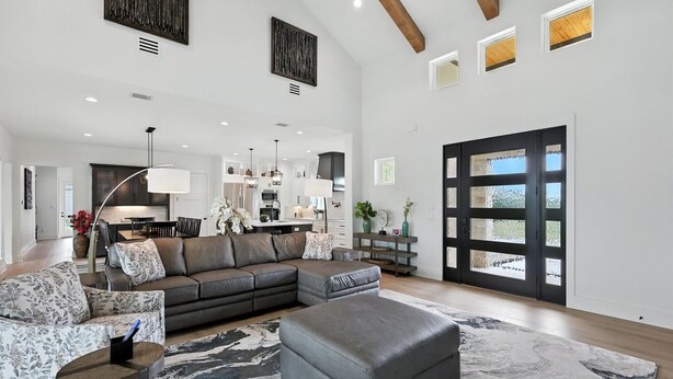 A spacious living area with a sectional sofa, ottoman, and patterned rug. - Heavenly Retreat 5bd/5.5ba of Waterfront living (Gainesville)