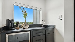 A modern kitchen with a window, a coffee maker, a roll of paper towels, and a sink. - Heavenly Retreat 5bd/5.5ba of Waterfront living (Gainesville)