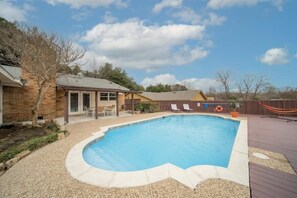 A backyard with a swimming pool, a wooden deck, and a fenced area with lounge chairs. - Open Space Home for Family, Groups With Privat Pool (Garland)