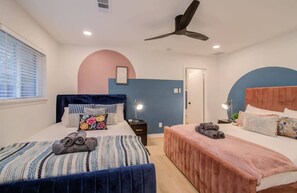 A bedroom with two beds, a ceiling fan, and a window with blinds. - Spring Branch Paradise, 4-bd Backyard Pool Oasis (Houston)