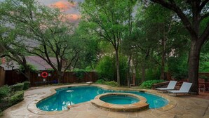 A backyard with a swimming pool and hot tub, surrounded by trees and a wooden fence. - Dallas Gem 5 Bedrooms Home With Pool, Game Room (Dallas)