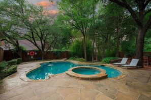 A backyard with a swimming pool and hot tub, surrounded by trees and a wooden fence. - Dallas Gem 5 Bedrooms Home With Pool, Game Room (Dallas)
