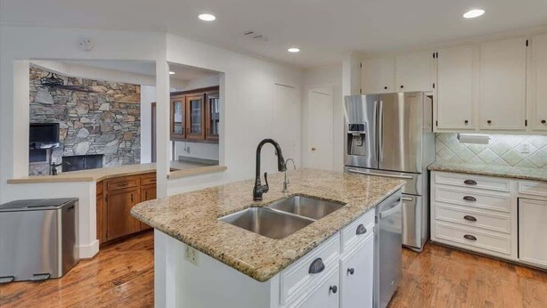 A modern kitchen with granite countertops, stainless steel appliances, and white cabinetry. - Dallas Gem 5 Bedrooms Home With Pool, Game Room (Dallas)