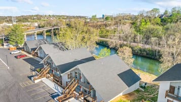 A hotel with a parking lot, a river, and a bridge in the background.