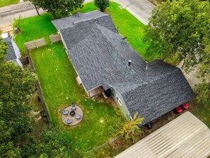 A residential house with a sloped roof, a fenced yard, and a circular outdoor seating area with chairs and a table. - Inactive (Sherman)