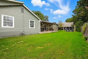 A house with a covered patio, a fenced yard, and a clear sky. - Inactive (Sherman)