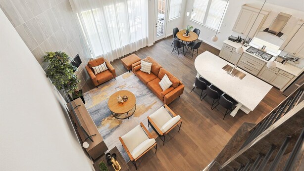 A spacious living area with a large window, a dining table, and a kitchen area. - Brand New 5bd, 4BA Luxury Vacation Home w Hot Tub (Irving)