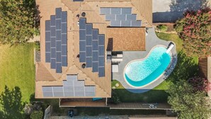 Ett tak med solpaneler, en swimmingpool och en uteplats.
