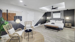 A modern bedroom with a bed, two chairs, a small table, a ceiling fan, and a skylight. - Relaxing Texas Retreat, 4BR w Pool & Dream Kitchen (DeSoto)