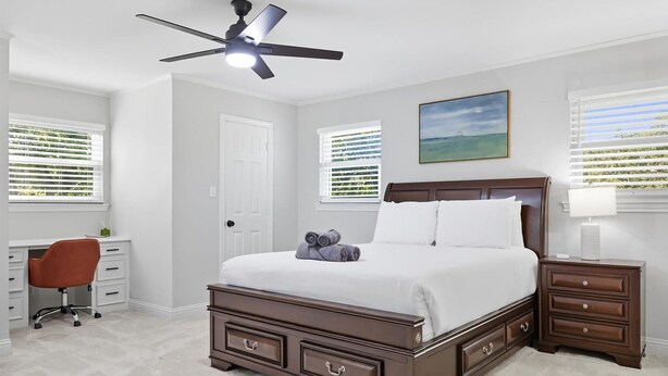 A bedroom with a bed, a desk, a chair, a nightstand, and a ceiling fan. - 5-bd/2.5-ba Modern Farmhouse Retreat (Flower Mound)