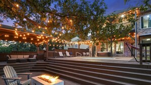 A deck with outdoor seating, a fire pit, and string lights. - Clearview Castle - Pool, Jacuzzi, Lake View (Lewisville)