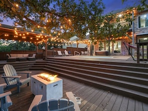 A deck with outdoor seating, a fire pit, and string lights. - Clearview Castle - Pool, Jacuzzi, Lake View (Lewisville)
