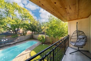 A backyard with a swimming pool, a hammock, and a hanging chair. - Bright and Spacious Home for w Pool -over 30 Nights- (Houston)