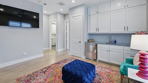 A modern kitchen with white cabinets, a stainless steel range, and a colorful rug. - Luxury Living at its Finest 3bd/3.5ba (Flower Mound)